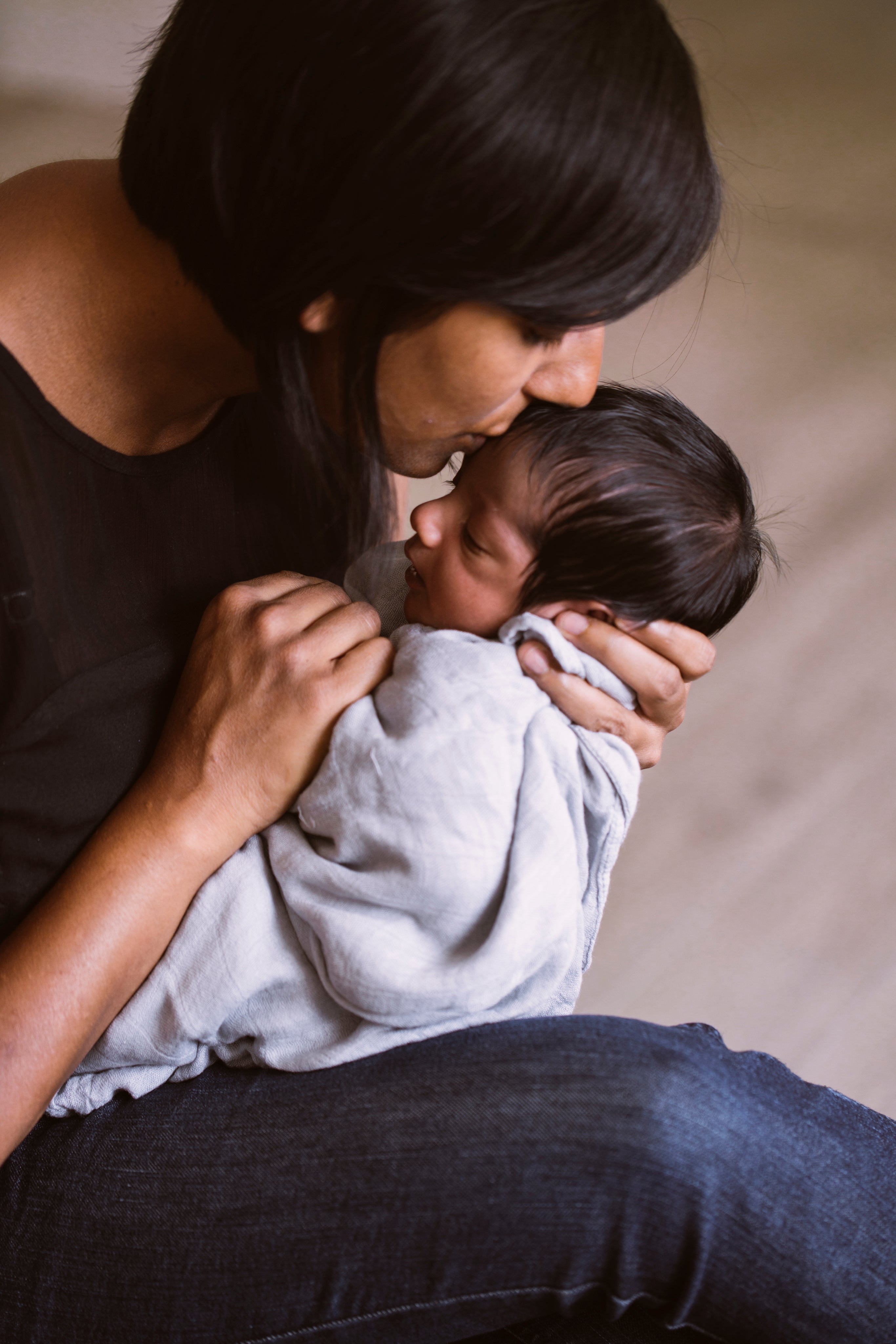 Mother kissing a newborn baby